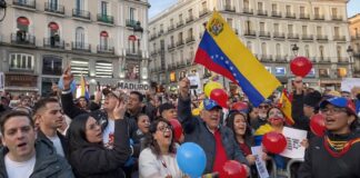 ¿Puede una intervención ser motivo de júbilo? Grupo de venezolanos en una plaza europea ondeando la bandera de Venezuela y globos de colores, algunos con expresiones de júbilo, durante una manifestación relacionada con la intervención de Estados Unidos en su país.
