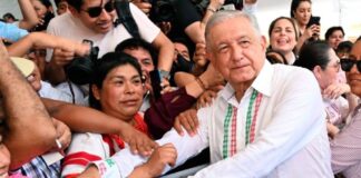 Los hijos de los personajes históricos Andrés Manuel López Obrador estrecha las manos de ciudadanos que lo rodean durante un acto público, mientras varias personas toman fotografías y observan de cerca su paso.